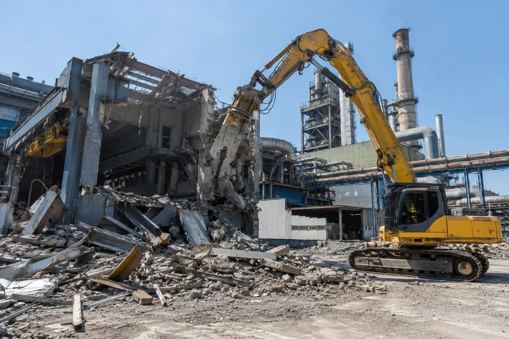 Excavator demolishing a commercial and industrial building for a demolition contractor in North Highlands, CA